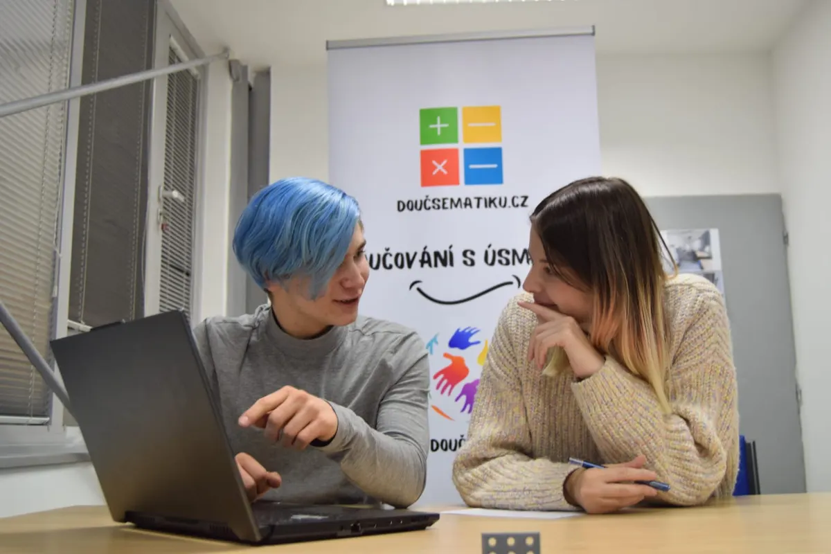 Doučování matematiky u Doučsematiku.cz: lektorka vysvětluje studentce příklad u notebooku.